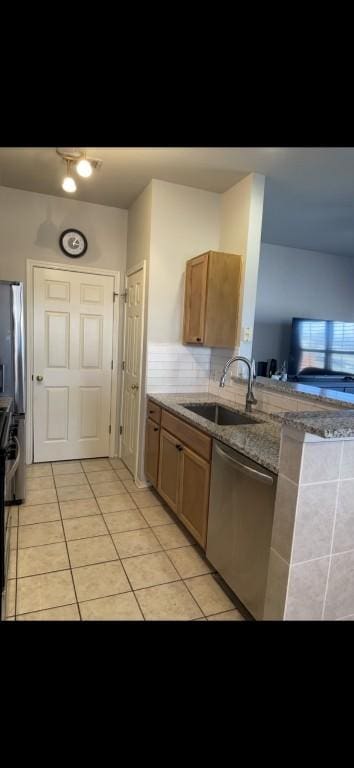 kitchen with appliances with stainless steel finishes, sink, and light tile patterned floors