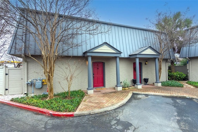 view of front of property featuring a gate, brick siding, and a swimming pool