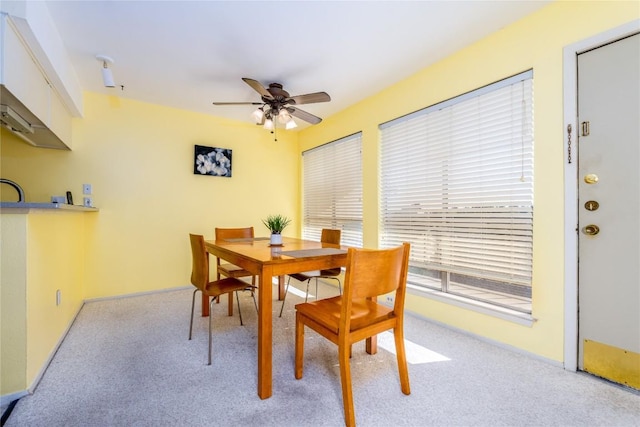 carpeted dining space featuring ceiling fan