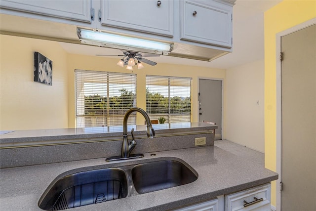 kitchen featuring white cabinetry, ceiling fan, and sink