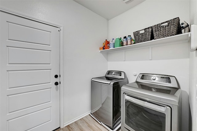 laundry area with separate washer and dryer and light wood-type flooring