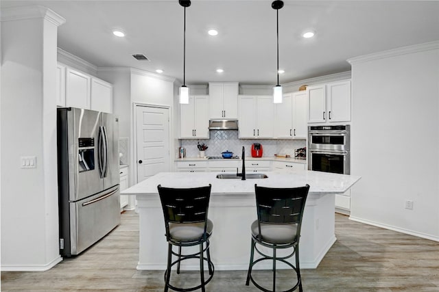 kitchen featuring stainless steel appliances, a kitchen island with sink, sink, and white cabinets