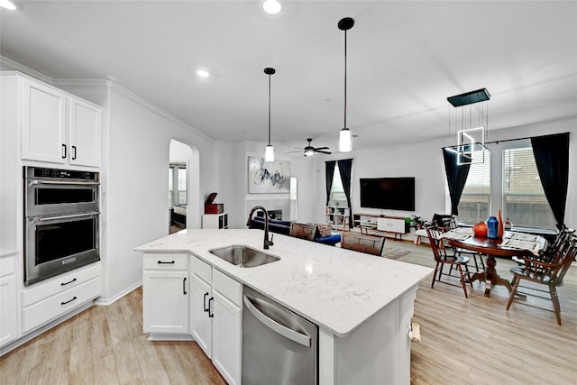 kitchen featuring pendant lighting, sink, stainless steel appliances, and white cabinets