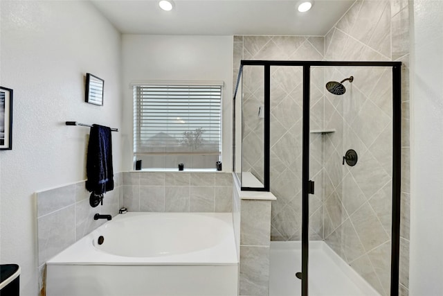 bathroom featuring shower with separate bathtub