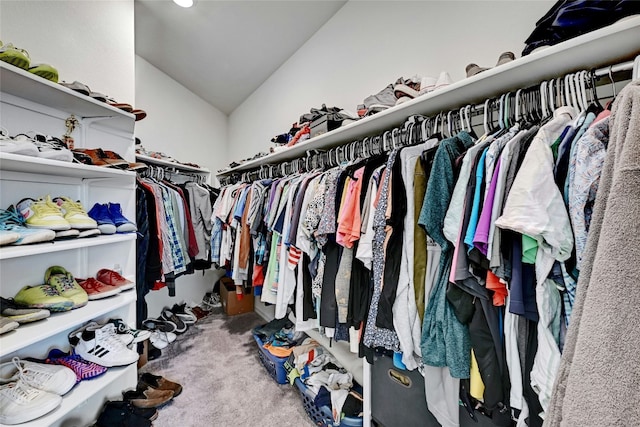 walk in closet with vaulted ceiling and carpet