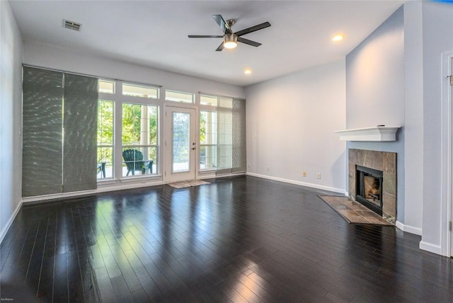 unfurnished living room featuring ceiling fan, dark hardwood / wood-style floors, and a tile fireplace