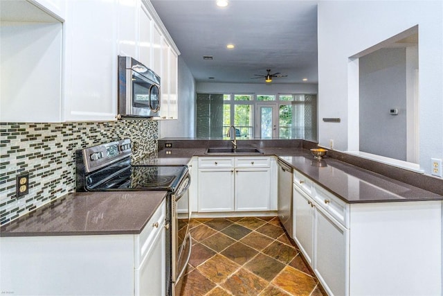 kitchen featuring stainless steel appliances, white cabinets, and kitchen peninsula