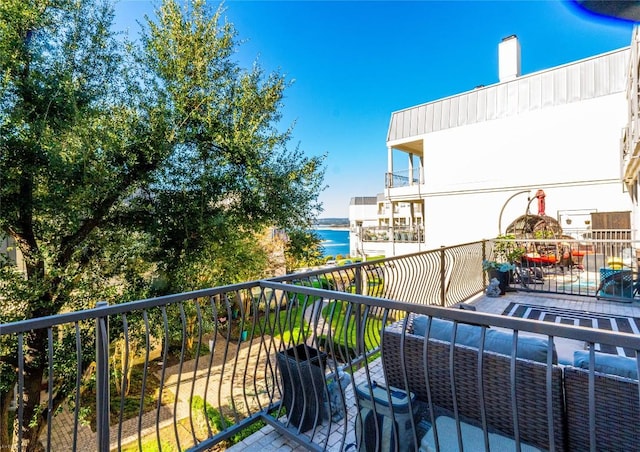 balcony with an outdoor hangout area and a water view