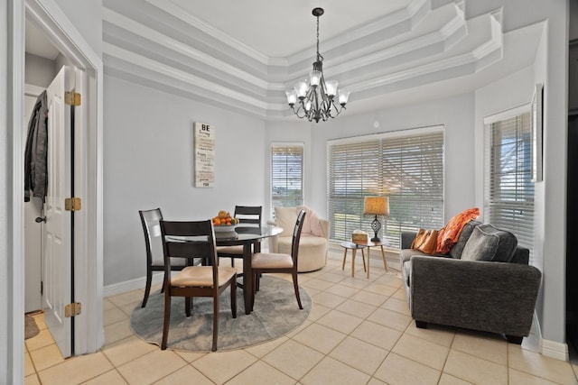 tiled dining area with a notable chandelier, ornamental molding, and a raised ceiling