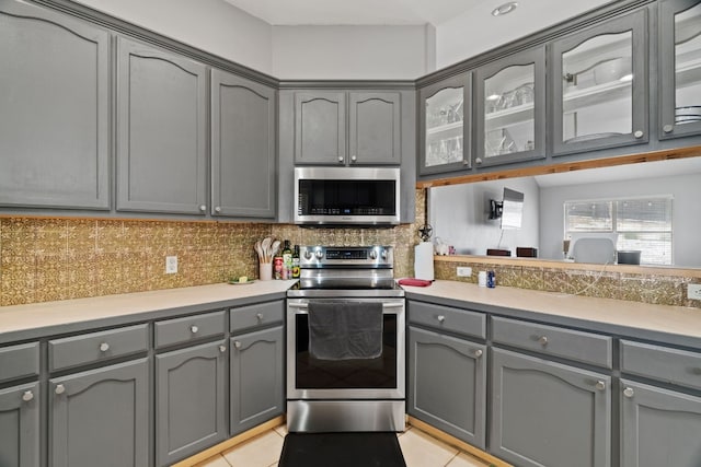 kitchen with backsplash, appliances with stainless steel finishes, and gray cabinetry