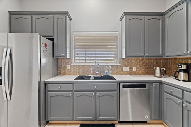 kitchen with gray cabinetry, sink, tasteful backsplash, and appliances with stainless steel finishes