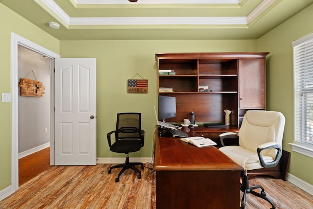 office with crown molding, a tray ceiling, and light hardwood / wood-style floors