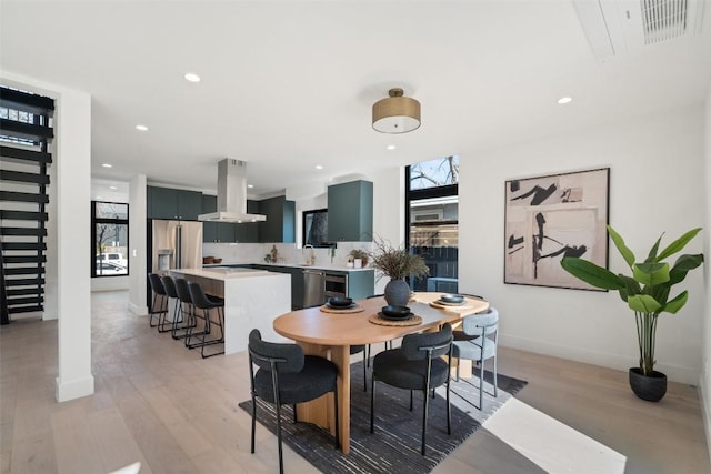 dining space featuring sink and light wood-type flooring