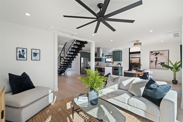 living room featuring ceiling fan and light hardwood / wood-style flooring