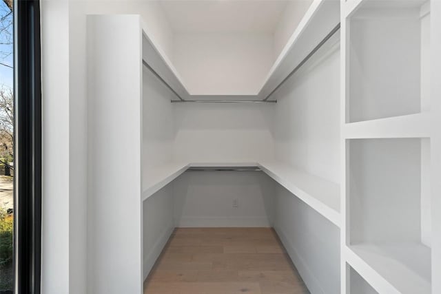 spacious closet featuring built in desk and hardwood / wood-style floors