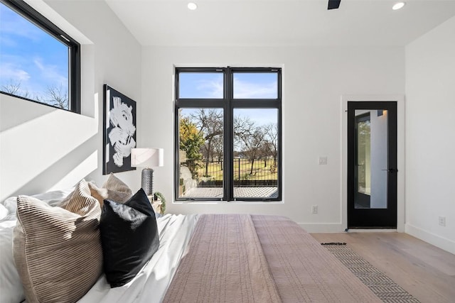 bedroom featuring multiple windows and light hardwood / wood-style flooring