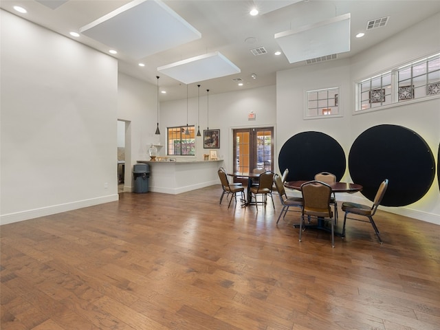 dining room featuring a high ceiling, dark wood-type flooring, and french doors