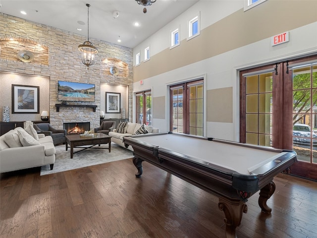 recreation room with french doors, a fireplace, plenty of natural light, and dark hardwood / wood-style flooring