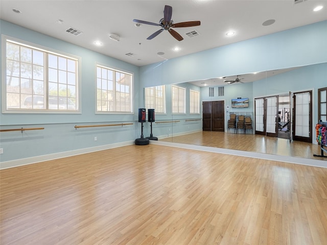 workout room with ceiling fan and light wood-type flooring