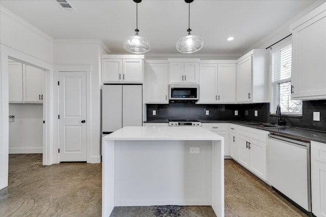 kitchen with pendant lighting, sink, white appliances, a center island, and white cabinets