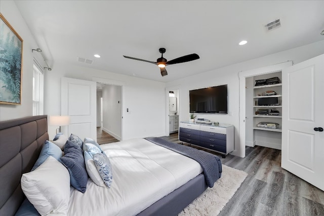 bedroom featuring hardwood / wood-style floors, a spacious closet, a closet, and ceiling fan