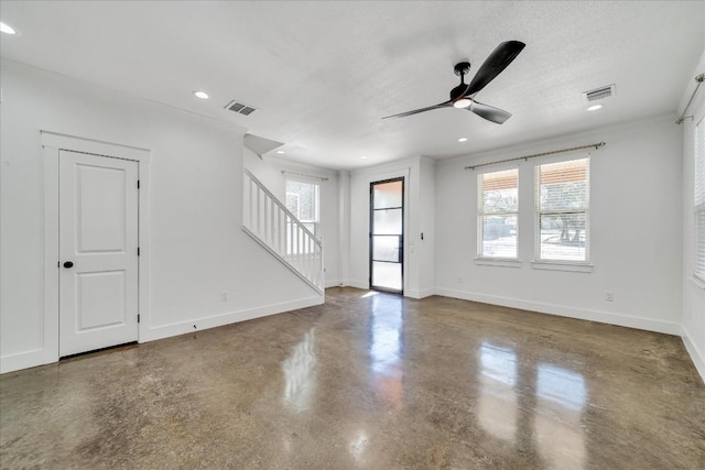 interior space with ceiling fan, concrete floors, and a textured ceiling