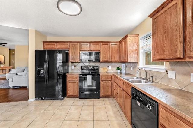 kitchen featuring light tile patterned flooring, sink, tasteful backsplash, and black appliances