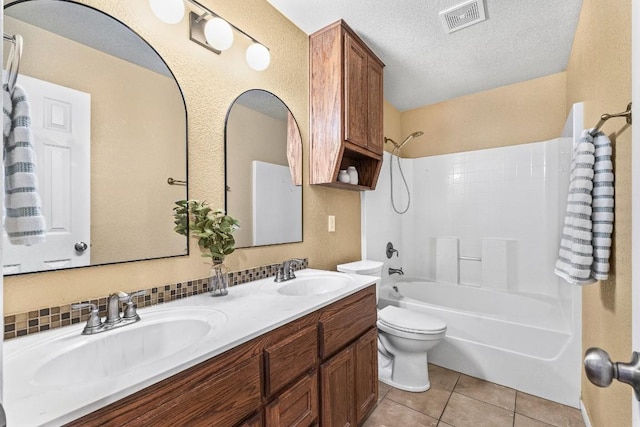 full bathroom with tile patterned floors, toilet, a textured ceiling, vanity, and shower / bath combination