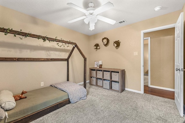 carpeted bedroom with a textured ceiling and ceiling fan