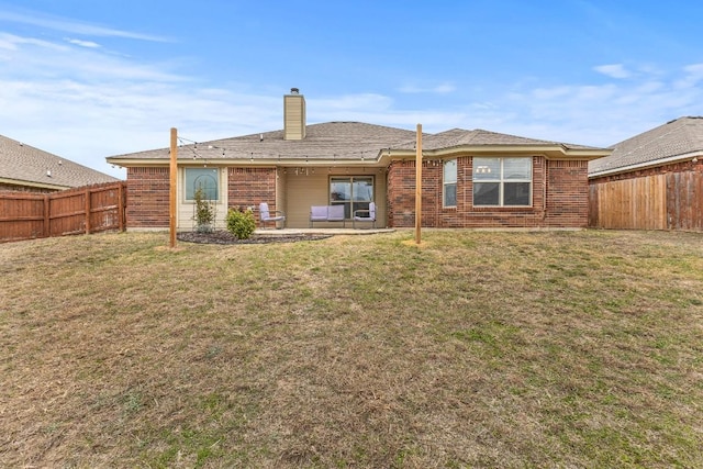 back of property with a yard and a patio area