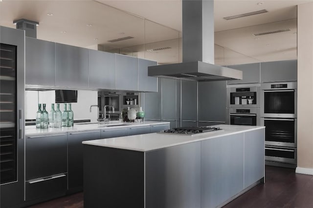 kitchen featuring sink, island range hood, a center island, appliances with stainless steel finishes, and dark hardwood / wood-style flooring