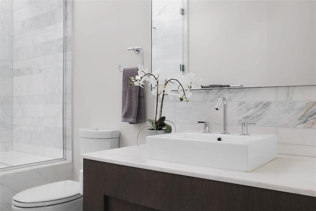 full bathroom featuring vanity, backsplash, shower / bath combination with glass door, and toilet