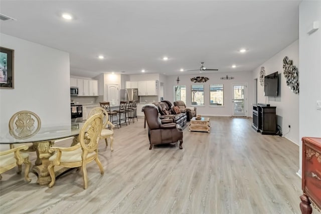 living room with ceiling fan and light hardwood / wood-style floors