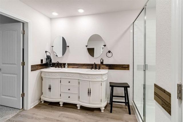 bathroom with vanity, wood-type flooring, and walk in shower