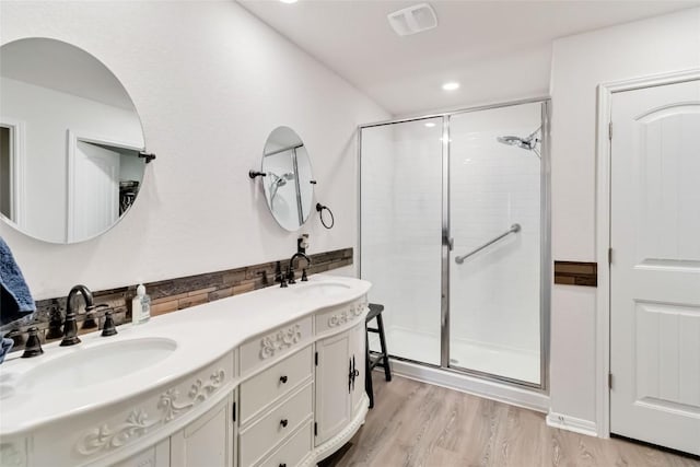 bathroom featuring walk in shower, vanity, and hardwood / wood-style floors