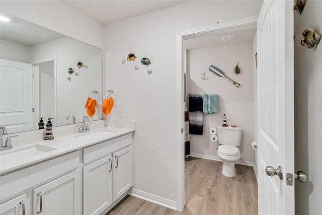 bathroom with hardwood / wood-style flooring, vanity, and toilet