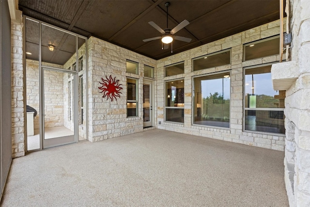 unfurnished sunroom featuring ceiling fan