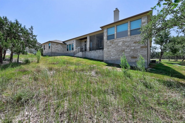 rear view of property featuring a sunroom