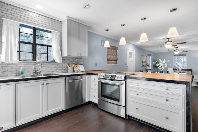 kitchen with sink, decorative light fixtures, stainless steel appliances, and white cabinets