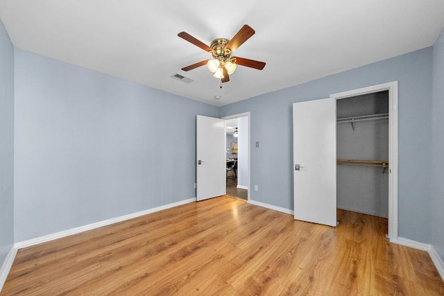 unfurnished bedroom featuring ceiling fan, light hardwood / wood-style floors, and a closet