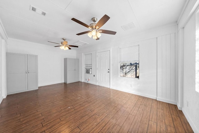 unfurnished living room featuring dark wood-type flooring and ceiling fan