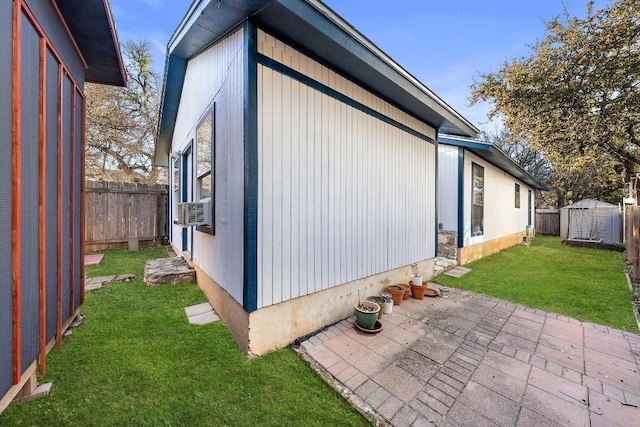 view of property exterior featuring a shed, cooling unit, a lawn, and a patio area