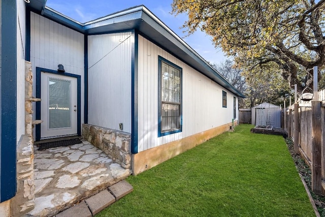 view of home's exterior featuring a yard and a storage unit