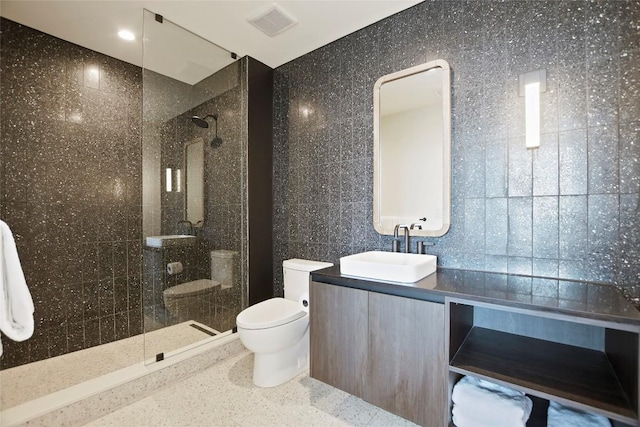 bathroom with vanity, toilet, and a tile shower