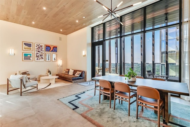 dining space with wood ceiling, a wall of windows, a notable chandelier, and a towering ceiling