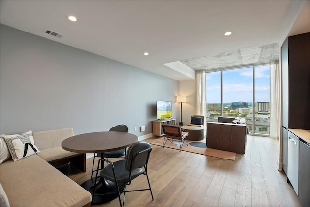 dining area with a wall of windows and light wood-type flooring