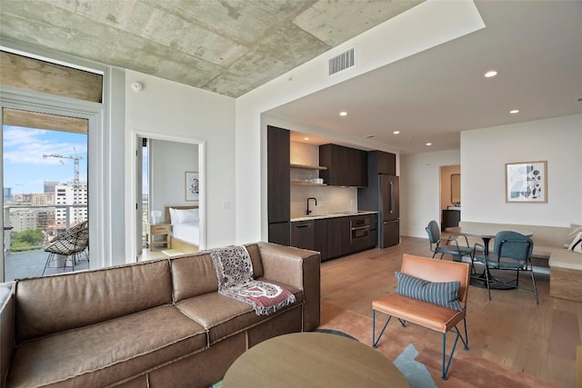 living room featuring sink and light hardwood / wood-style floors