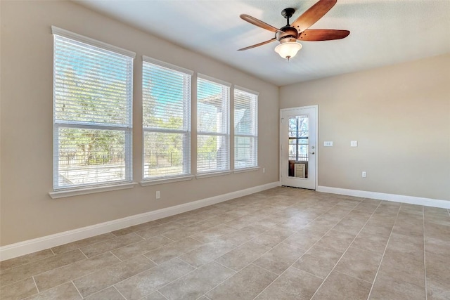 spare room with ceiling fan and light tile patterned floors