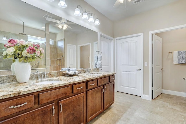 bathroom with vanity, tile patterned flooring, ceiling fan, and tiled shower