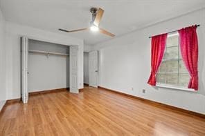 unfurnished bedroom featuring ceiling fan, wood-type flooring, and a closet